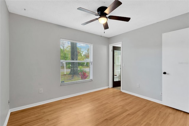 unfurnished room with a ceiling fan, light wood-style flooring, and baseboards