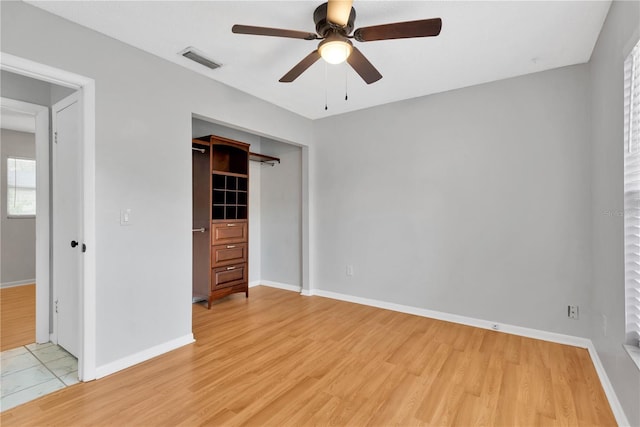 unfurnished bedroom featuring a closet, light wood-type flooring, visible vents, and baseboards