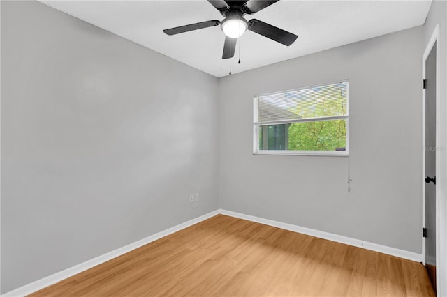 empty room with light wood-type flooring, a ceiling fan, and baseboards