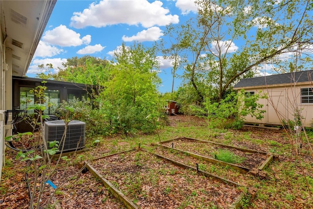 view of yard with central AC, a shed, an outdoor structure, and a garden