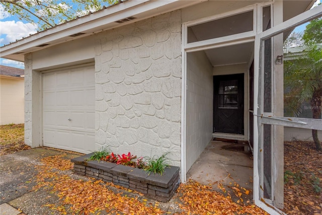 property entrance featuring a garage and driveway