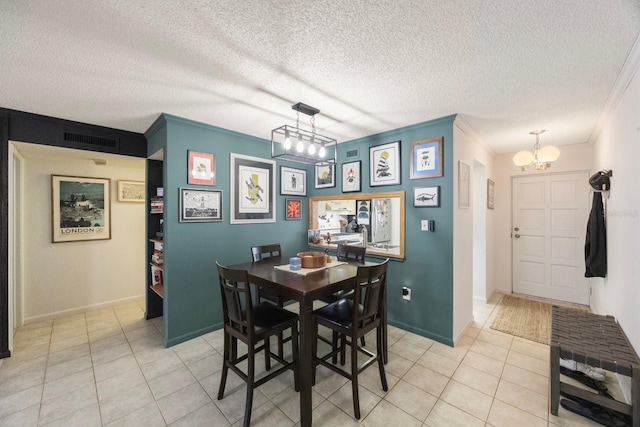 dining area featuring visible vents, ornamental molding, a textured ceiling, and light tile patterned flooring