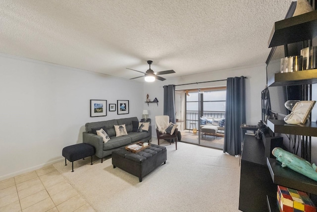 tiled living area featuring ceiling fan, baseboards, and a textured ceiling