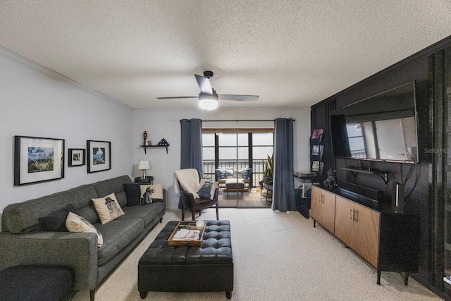 living room with ceiling fan, ornamental molding, a textured ceiling, and light colored carpet