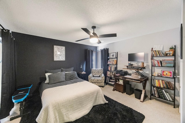 bedroom with light carpet, a ceiling fan, and a textured ceiling