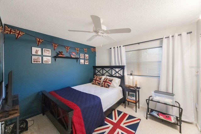 carpeted bedroom with a ceiling fan, a textured ceiling, and baseboards