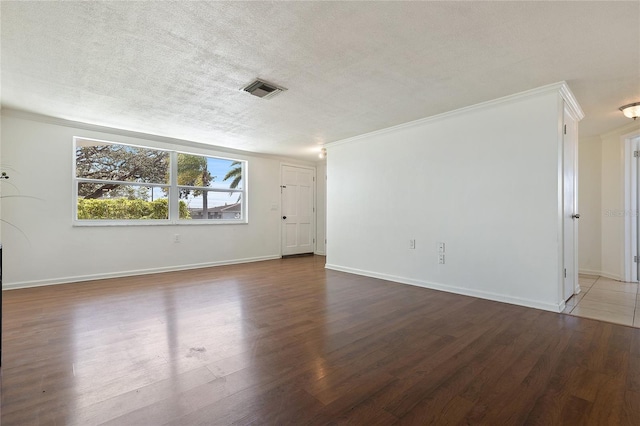 unfurnished room with visible vents, a textured ceiling, and wood finished floors