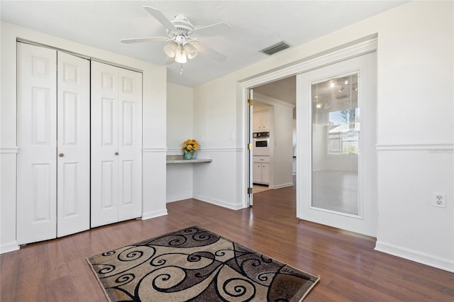 interior space with dark wood-style floors, baseboards, visible vents, and a closet