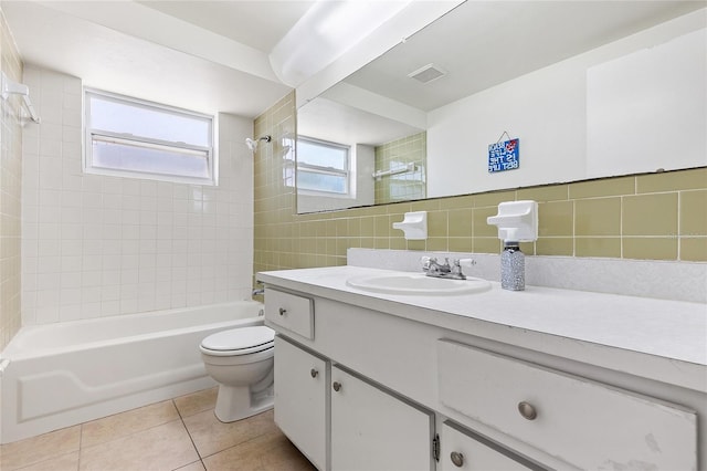 full bath featuring toilet, tile patterned flooring, vanity, shower / washtub combination, and tile walls