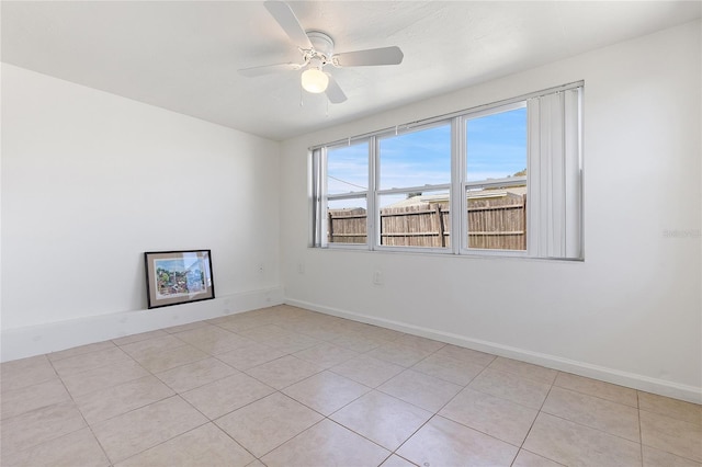 spare room with light tile patterned flooring, ceiling fan, and baseboards