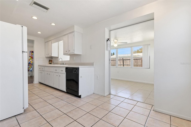 kitchen featuring a sink, visible vents, black dishwasher, light countertops, and freestanding refrigerator