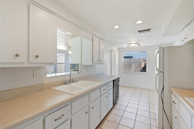 kitchen featuring visible vents, a sink, backsplash, and dishwasher