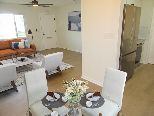 dining room featuring wood finished floors, a ceiling fan, and baseboards