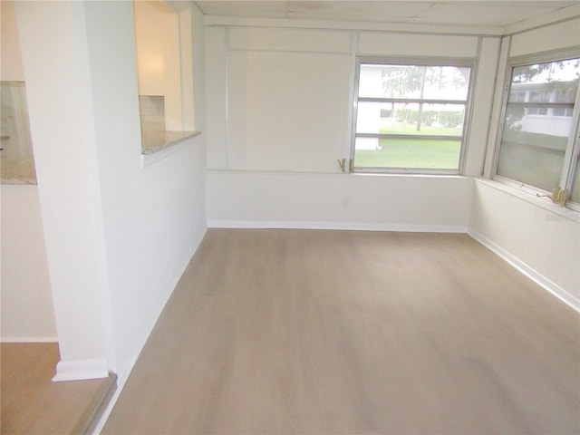 spare room featuring light wood-style flooring and baseboards