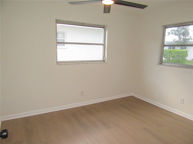 unfurnished room featuring a ceiling fan, baseboards, and wood finished floors