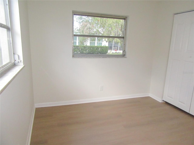 empty room with baseboards and wood finished floors