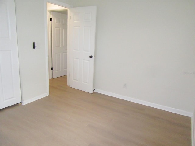 empty room with baseboards and wood finished floors