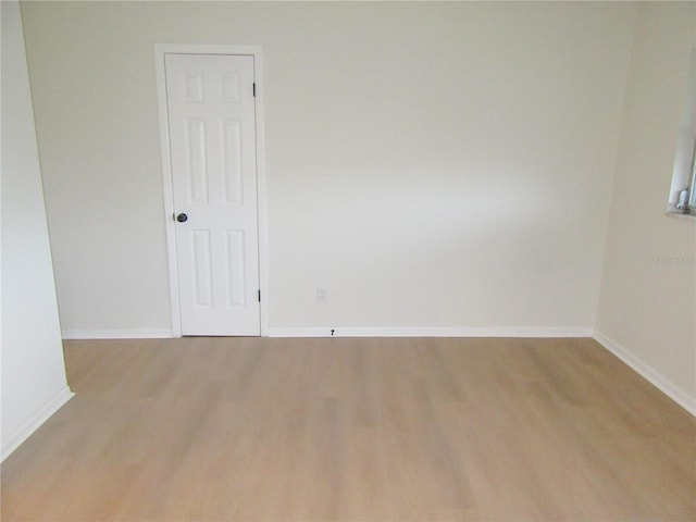 spare room with light wood-style floors and baseboards