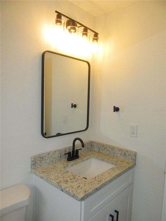 half bath featuring toilet and vanity