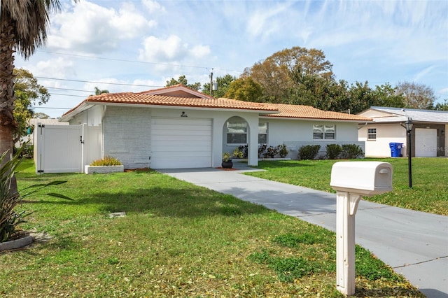 view of front facade featuring a tile roof, stucco siding, a front yard, a garage, and driveway