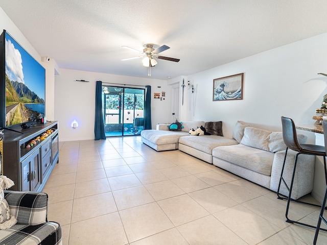 living area with light tile patterned floors, a textured ceiling, and a ceiling fan