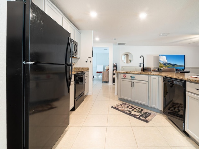 kitchen with a sink, visible vents, black appliances, and light tile patterned floors