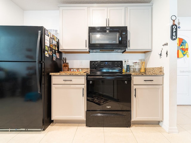 kitchen with black appliances, light tile patterned floors, and light stone countertops