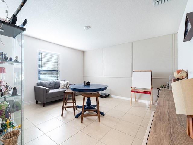 interior space with light tile patterned floors, visible vents, and a textured ceiling