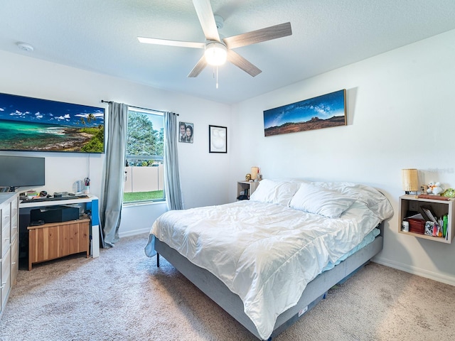 bedroom featuring light colored carpet, baseboards, and a textured ceiling