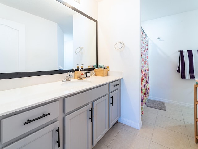 bathroom with baseboards, vanity, and tile patterned flooring