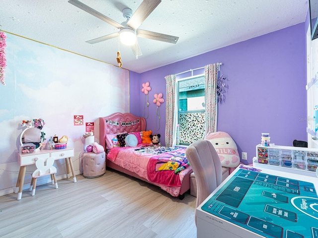 bedroom with a textured ceiling, ceiling fan, and wood finished floors