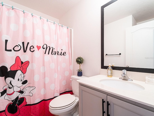 bathroom featuring vanity, curtained shower, toilet, and a textured ceiling