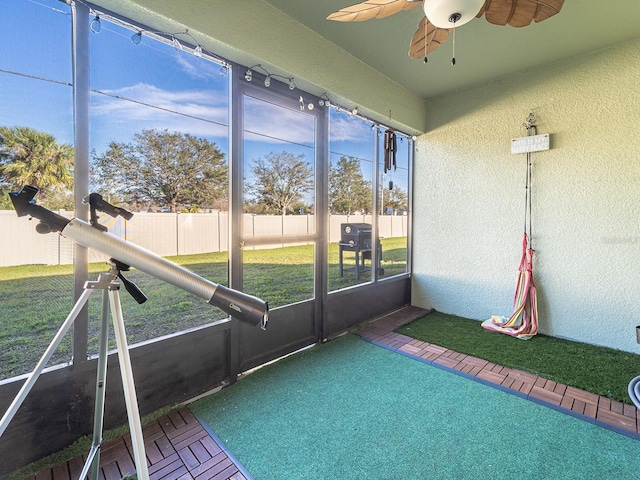 unfurnished sunroom featuring a ceiling fan