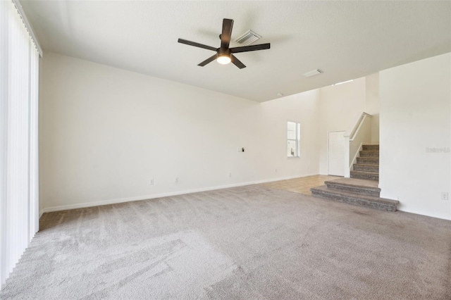 unfurnished living room featuring stairway, carpet flooring, visible vents, and a ceiling fan