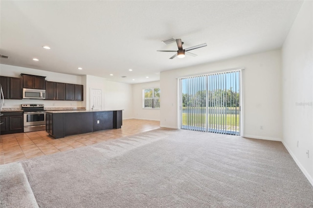 kitchen featuring a ceiling fan, visible vents, appliances with stainless steel finishes, light carpet, and open floor plan