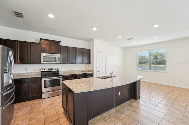 kitchen with visible vents, dark brown cabinets, light tile patterned floors, stainless steel appliances, and a sink