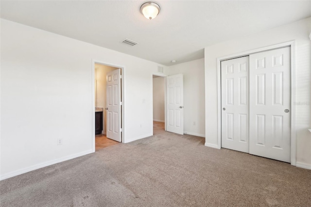 unfurnished bedroom with a closet, visible vents, baseboards, and carpet floors