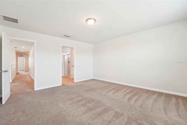 unfurnished bedroom featuring visible vents, light colored carpet, and baseboards