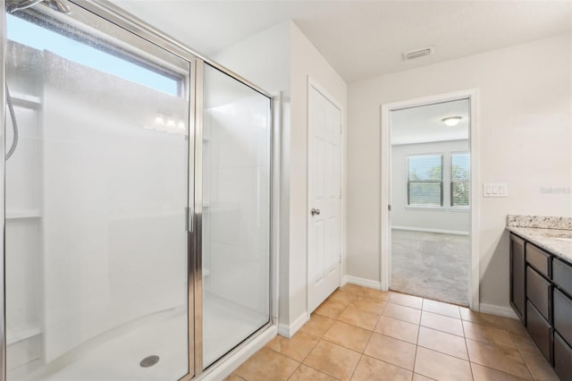 bathroom featuring vanity, baseboards, visible vents, a shower stall, and tile patterned floors