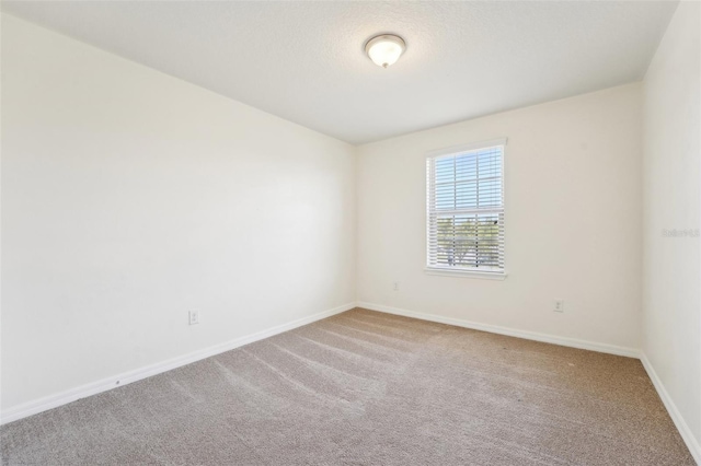 unfurnished room with baseboards and carpet flooring