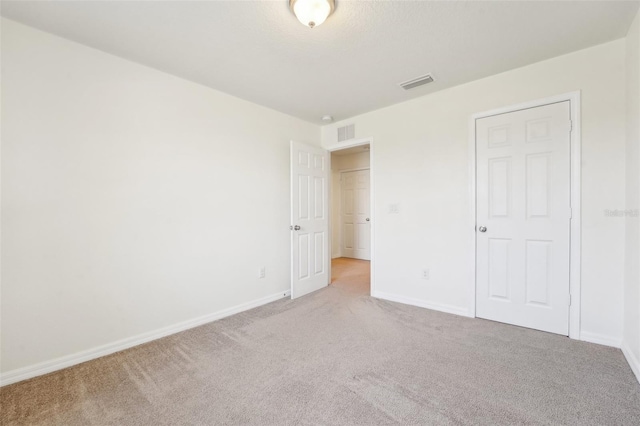 unfurnished bedroom featuring carpet, visible vents, and baseboards