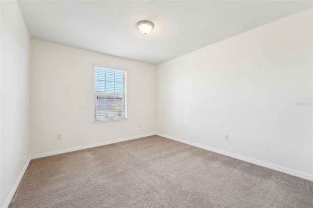 unfurnished room with baseboards and carpet flooring