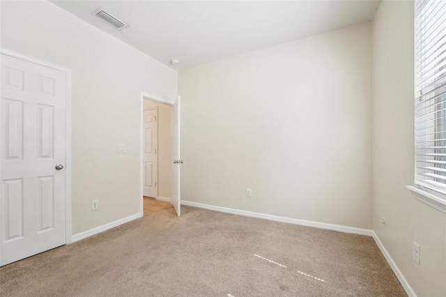 unfurnished bedroom with visible vents, baseboards, and light colored carpet