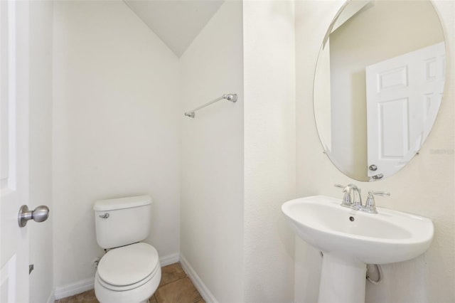 bathroom featuring tile patterned flooring, lofted ceiling, toilet, and baseboards