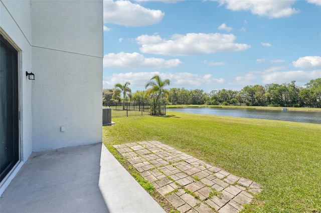 view of yard with a water view, central AC unit, and fence