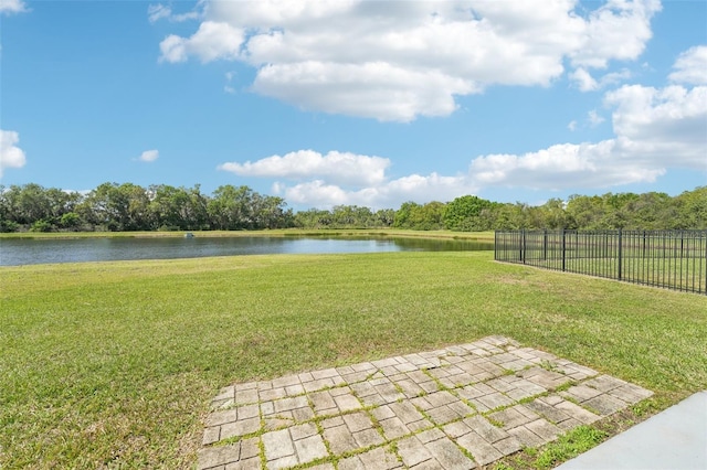 view of yard with a patio area, fence, and a water view