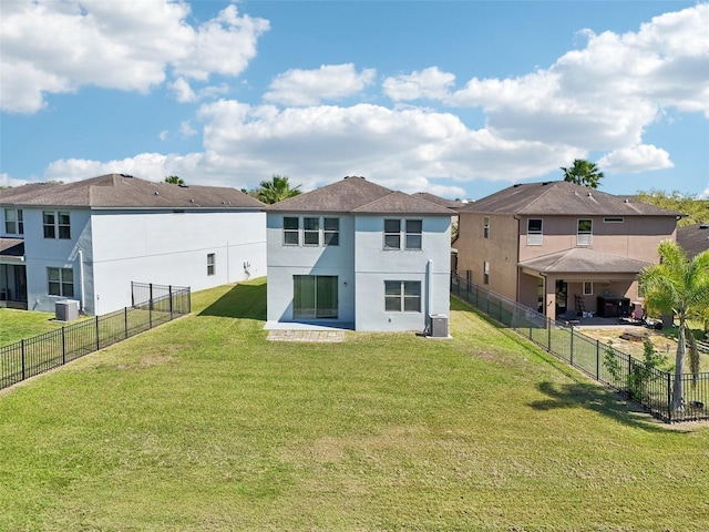 rear view of house featuring a residential view, central air condition unit, stucco siding, a fenced backyard, and a yard