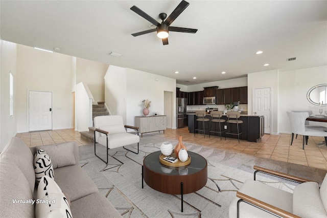 living room featuring visible vents, ceiling fan, stairway, light tile patterned floors, and recessed lighting