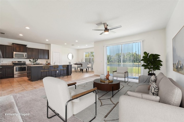 living area featuring light tile patterned flooring, recessed lighting, visible vents, and ceiling fan