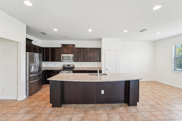 5955 Sweet Birch Dr, Riverview, FL 33578 - kitchen with appliances with stainless steel finishes, recessed lighting, dark brown cabinetry, light stone counters, and a center island with sink